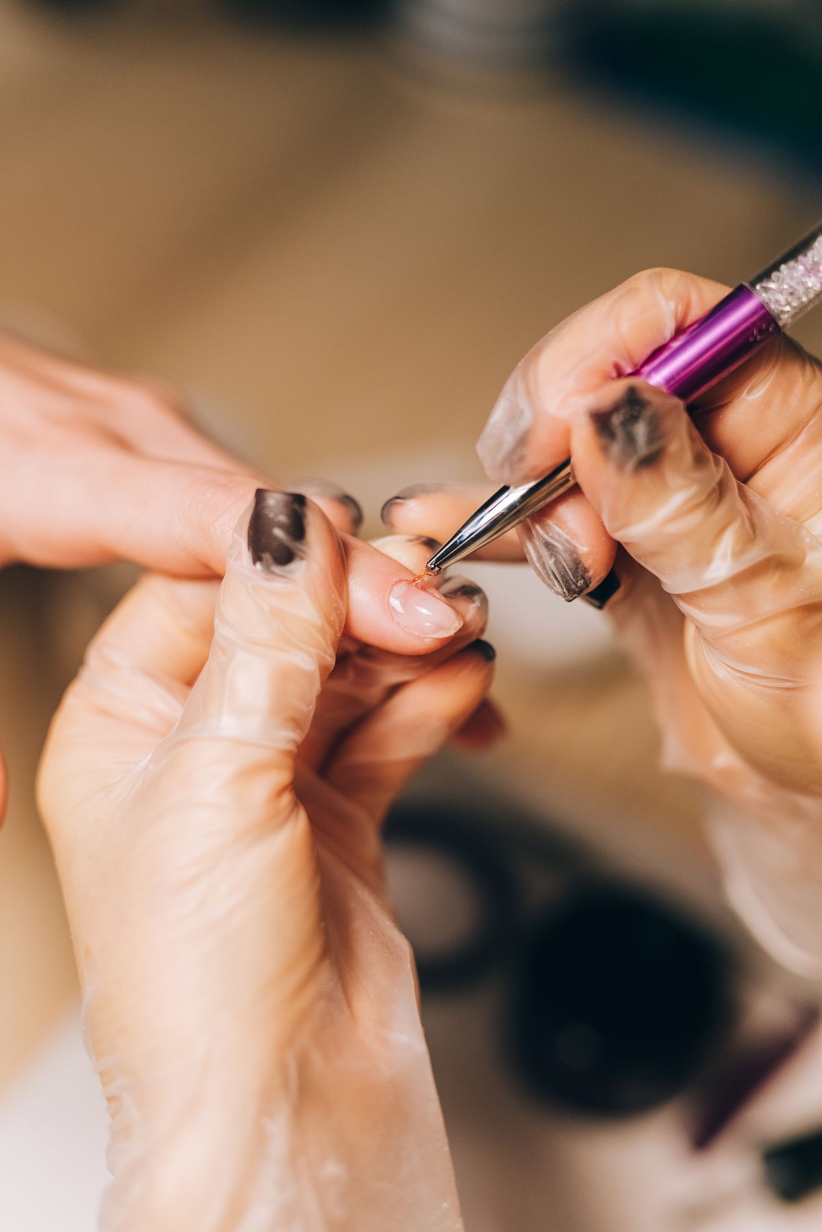 Close-up of a manicurist applying nail polish during a professional salon treatment.